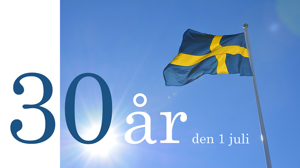 Svenska flaggan på en blå himmel med texten Vöfab 30 år den 1 juli