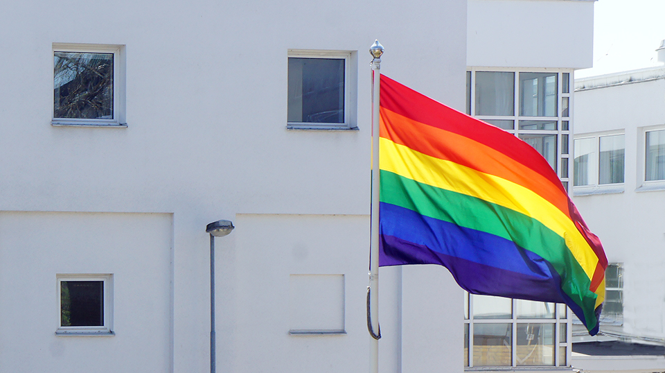 En Pride-flagga vajar utanför en husfasad
